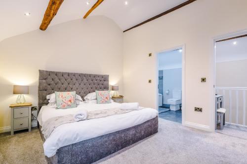 a bedroom with a large bed and a bathroom at Stunning 3-bed cottage in Beeston by 53 Degrees Property, ideal for Families & Groups, Great Location - Sleeps 6 in Beeston