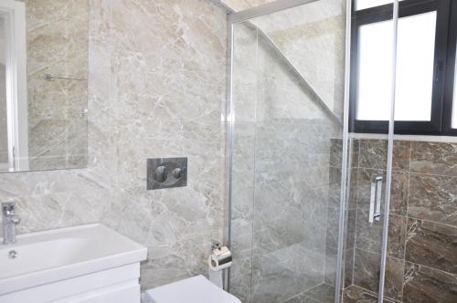 een badkamer met een douche, toilet en wastafel bij Hisar Prestige D in Fethiye