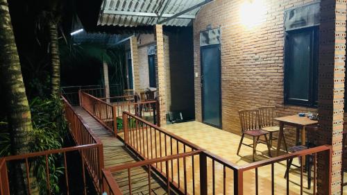 a balcony with a table and chairs and a brick building at Gibbon Singing Home Stay in Quan Tom