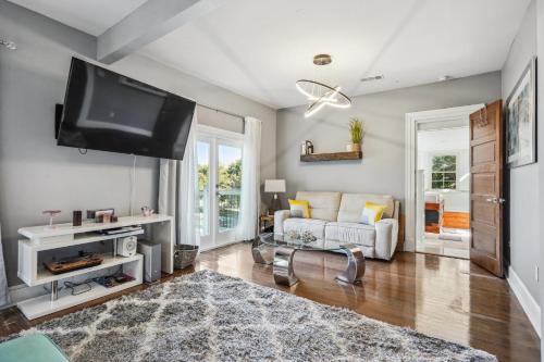 a living room with a couch and a flat screen tv at GrandCraftsman style home with pool and hot tub/ center to all of New Orleans in New Orleans