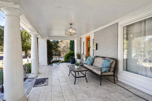 a porch with a couch and a table on a house at GrandCraftsman style home with pool and hot tub/ center to all of New Orleans in New Orleans