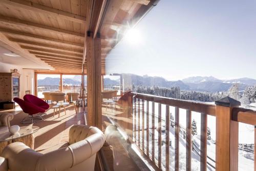 a room with a balcony with a view of the mountains at Hotel Tann in Collalbo