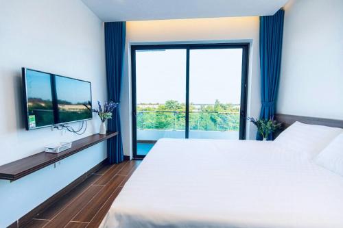 a bedroom with a large bed and a large window at Villa FLC Sầm Sơn - Cạnh Bể Bơi Vô Cực in Sầm Sơn