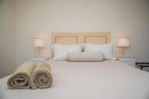 ein Schlafzimmer mit einem weißen Bett mit Handtüchern darauf in der Unterkunft Grootvlei Guest Farm in Lambertʼs Bay