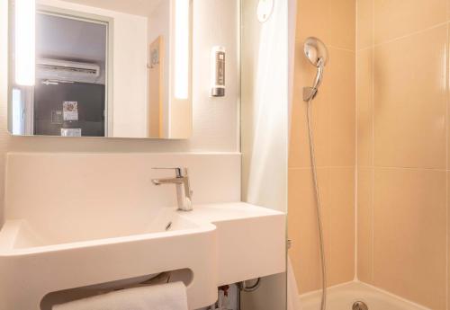y baño blanco con lavabo y ducha. en B&B HOTEL Toulon La Seyne sur Mer en La Seyne-sur-Mer