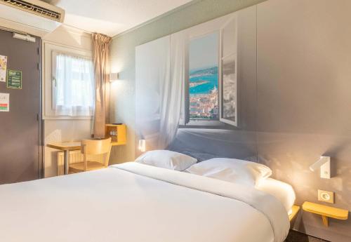 Un dormitorio con una gran cama blanca y una ventana en B&B HOTEL Toulon La Seyne sur Mer en La Seyne-sur-Mer