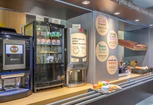 a coffee shop with a counter with a drink refrigerator at B&B HOTEL Toulon La Seyne sur Mer in La Seyne-sur-Mer
