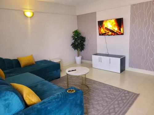 a living room with a blue couch and a fireplace at Wike Suites in Nakuru
