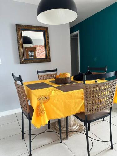 a dining room table with a yellow table cloth on it at Apto melhor localização do Cocó in Fortaleza