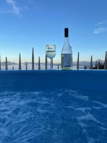 a bottle and a glass of wine next to a swimming pool at Bayernhütte am Brauneck in Lenggries