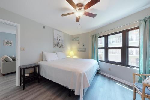 - une chambre avec un lit blanc et un ventilateur de plafond dans l'établissement Harbour Place, à Gulf Shores