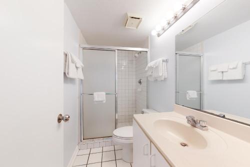 La salle de bains blanche est pourvue d'un lavabo et de toilettes. dans l'établissement Harbour Place, à Gulf Shores