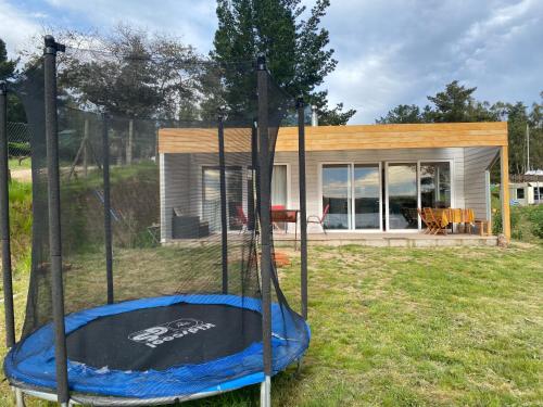 a small house with a trampoline in the yard at Casa Lago Rapel - Punta Verde in Lago Rapel