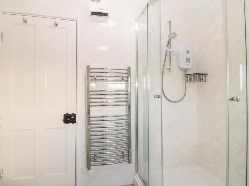 baño blanco con ducha y puerta de cristal en 2 Bryn Hyfryd, en Abersoch