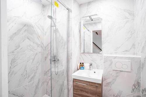 a white bathroom with a shower and a sink at 31 - Urban Keith Harings in Paris