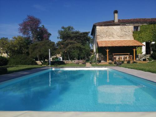 a swimming pool in front of a house at Les Granges de la Leigne, Ruffec in Condac