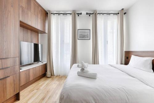 une chambre avec un lit avec un ours en peluche dessus dans l'établissement MyKeypers - Amazing Luxe & Cosy Flat 2BR/6P - Bastille, à Paris