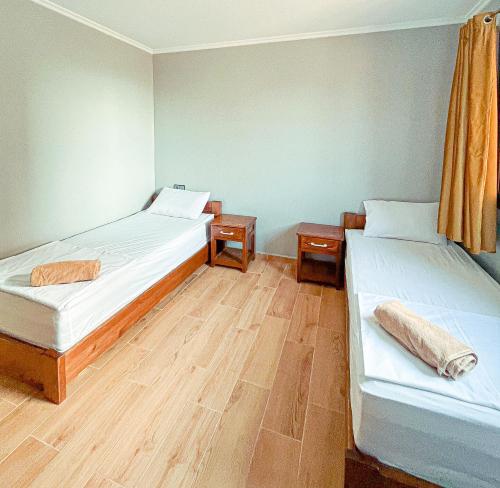Duas camas num quarto com pisos em madeira em corner House em Imsouane