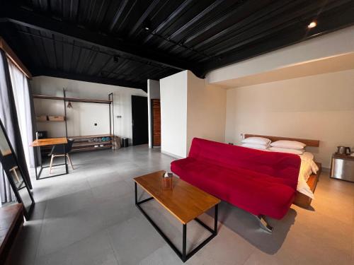 チャングーにあるRumah Kahyanganのベッドルーム1室(ベッド1台、赤いソファ付)