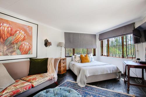 a bedroom with two beds and a couch at The River Cottage in Muldersdrift