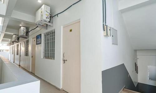 a hallway of a hospital with white walls and doors at FabExpress Ashiyana Inn in Patna