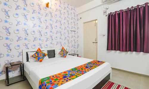 a bedroom with a bed and a wall with blue at FabExpress Ashiyana Inn in Patna