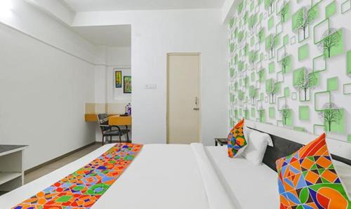 a bedroom with a large white bed with colorful pillows at FabExpress Ashiyana Inn in Patna