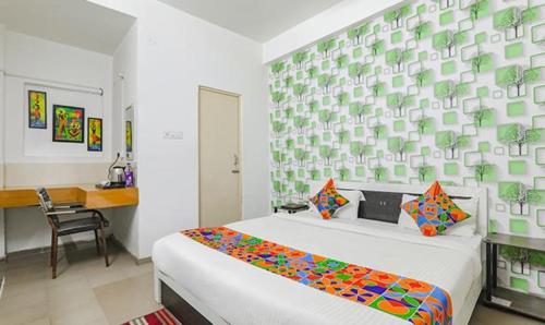 a bedroom with a bed and a desk in it at FabExpress Ashiyana Inn in Patna