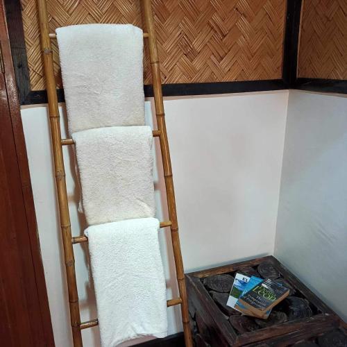 a towel rack in a room with white towels at Hidden of Cailan Extension Transient House in El Nido