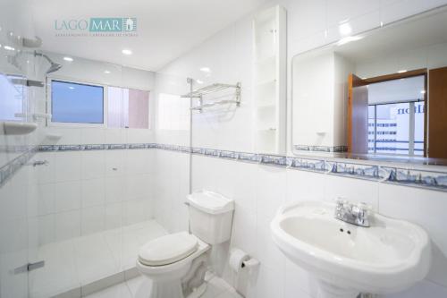 Baño blanco con aseo y lavamanos en Lagos y Mar Apartamentos Cartagena, en Cartagena de Indias