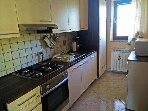 a kitchen with white cabinets and a stove top oven at Anica Apartment in Banjole