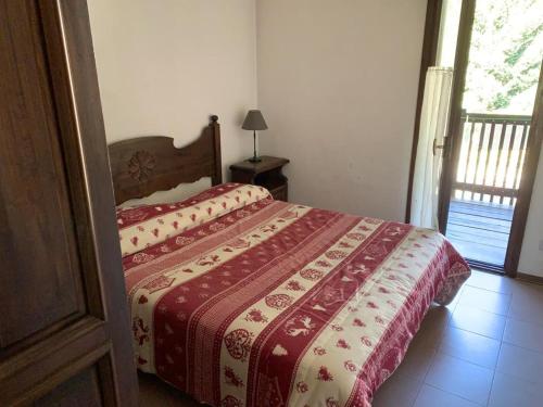 a bedroom with a bed with a red and white blanket at Casa Bianchina La Thuile in La Thuile