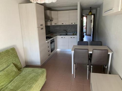 eine Küche mit einem Tisch, Stühlen und einem Sofa in der Unterkunft Casa Bianchina La Thuile in La Thuile