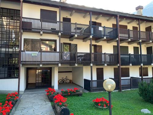 - un bâtiment avec des balcons et des fleurs dans une cour dans l'établissement Casa Bianchina La Thuile, à La Thuile
