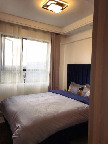 una camera da letto con un grande letto e una finestra di Furnished apartment in Lavington a Nairobi