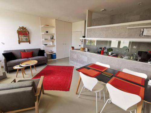 uma sala de estar com um sofá, uma mesa e cadeiras em Saint-Jean de Luz, proche du centre ville - 2/4 personnes - 3* em Sainte-Barbe
