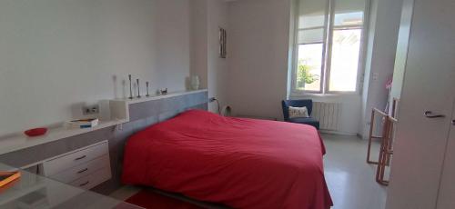 um quarto com uma cama vermelha e uma secretária em Saint-Jean de Luz, proche du centre ville - 2/4 personnes - 3* em Sainte-Barbe