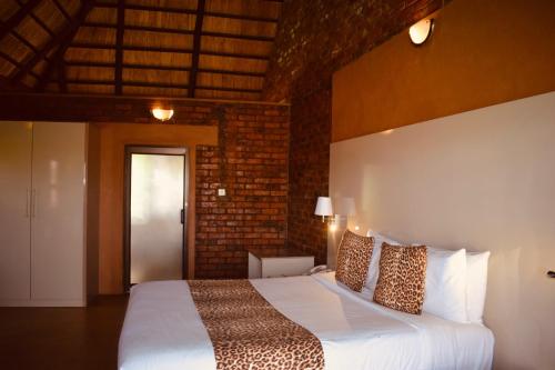 a bedroom with a bed and a brick wall at Deluxe room on a resort - 2182 in Kingsmead