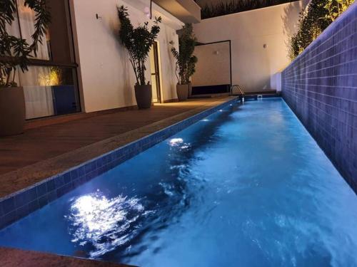 a swimming pool with blue water in a building at Apartamento 2 Suítes com piscina e churrasqueira, ao lado da UFSC in Florianópolis