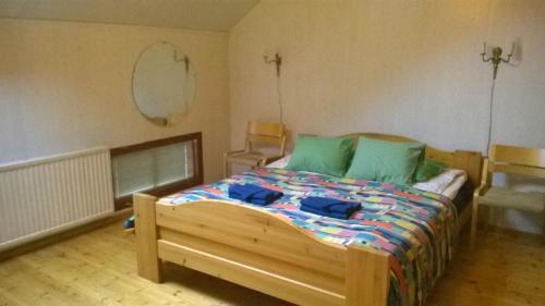 - une chambre avec un lit en bois et des oreillers verts dans l'établissement Suvannonrannan Majoitukset, à Kauhajoki