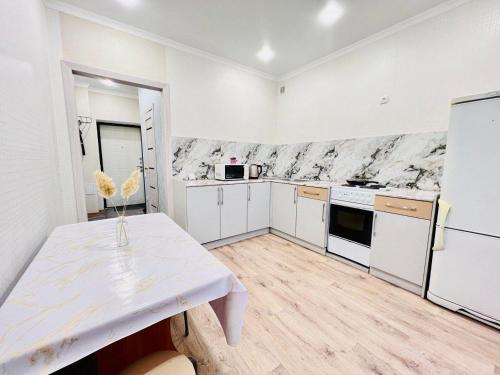 卡拉干達的住宿－ЖК Алтын бесік，厨房配有白色橱柜和白色桌子