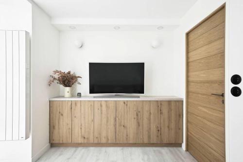 un salon avec une télévision sur un meuble en bois dans l'établissement MyKeypers - Cosy & Design Parisian Flat 4P - Batignolles, à Paris