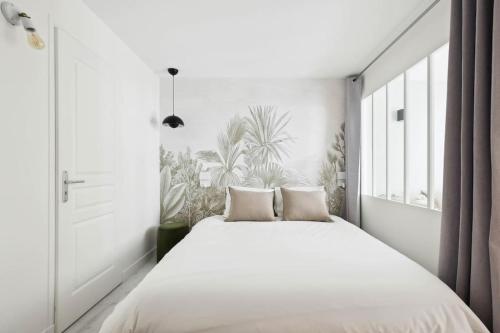 une chambre avec un grand lit blanc avec deux oreillers dans l'établissement MyKeypers - Cosy & Design Parisian Flat 4P - Batignolles, à Paris