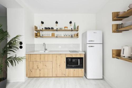 une cuisine avec un évier et un réfrigérateur dans l'établissement MyKeypers - Cosy & Design Parisian Flat 4P - Batignolles, à Paris