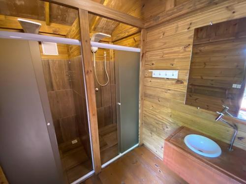 baño con paredes de madera, aseo y lavamanos en Espaço AVIVA en Florianópolis