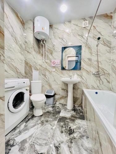 卡拉干達的住宿－ЖК Алтын бесік，浴室配有卫生间水槽和洗衣机。