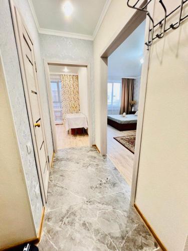 卡拉干達的住宿－ЖК Алтын бесік，走廊上设有1间带桌子的房间和1间卧室