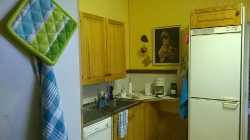 a kitchen with wooden cabinets and a white refrigerator at Suvannonrannan Majoitukset in Kauhajoki