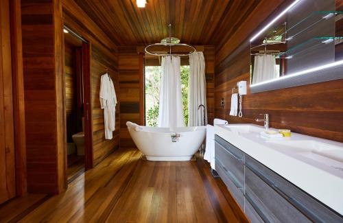 a bathroom with a tub and two sinks and a window at Secret Bay in Portsmouth