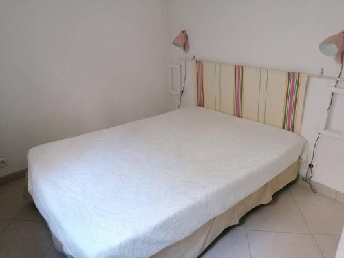 ein kleines weißes Bett in einem kleinen Zimmer in der Unterkunft Saint-Jean de Luz, T2 bis terrasse 3 couchages in Sainte-Barbe